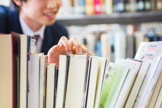 高中学生在图书馆里寻找书籍特写图片