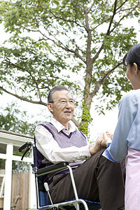 护工推着轮椅上的老人户外散步图片