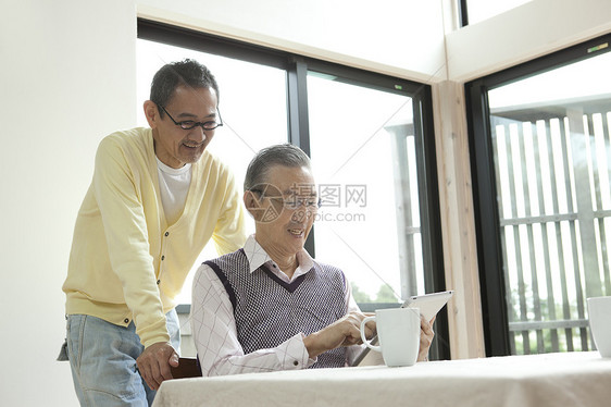 两位老年挚友一起看平板电脑图片