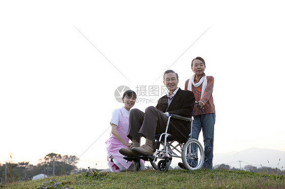 护工推着轮椅上的老爷爷户外散步图片