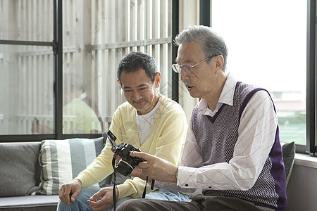 两位老年挚友一起研究相机图片