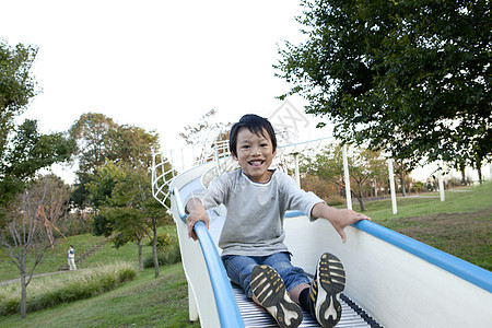 公园里玩滑滑梯的小男孩图片