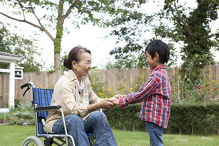 孙子推轮椅上的奶奶到花园里散步图片