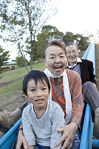 公园里陪孙子玩滑滑梯的爷爷奶奶图片