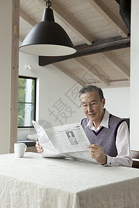 老年男性独自居家看报纸图片