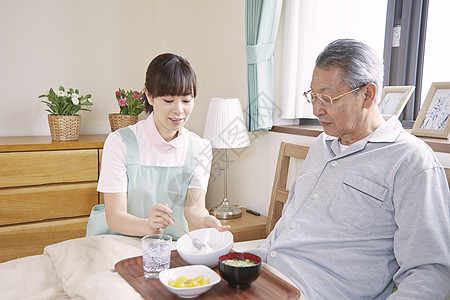 护理员在给老人喂饭图片