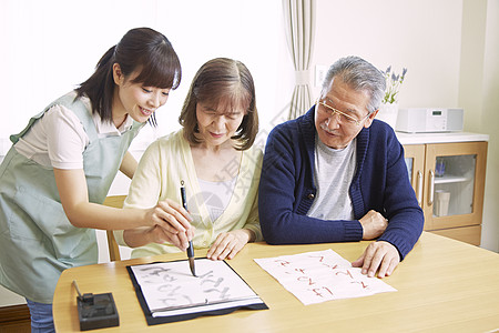 女性护工陪伴居家老人写书法图片