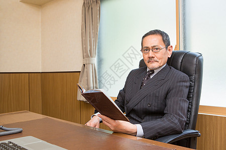 坐在办公室椅子上的老板形象背景图片