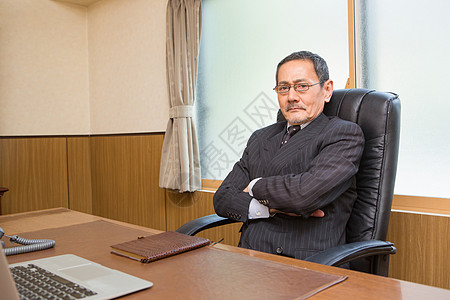 坐在办公室交叉双手严肃的老板图片素材