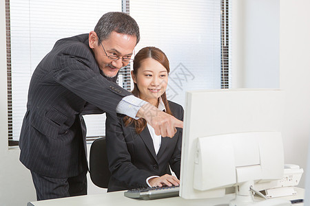 电脑前老板指导商务女白领图片