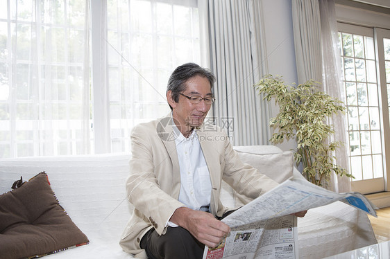 老年男性沙发上看报纸图片