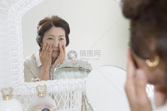 老年女性镜子前查看皱纹图片