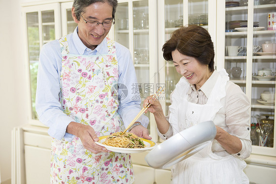 中年夫妇在厨房烹饪食物图片