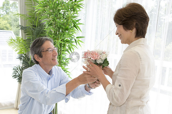 中年男性在向妻子献花图片