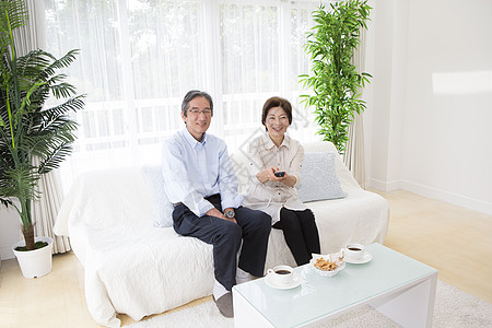 在客厅喝茶看电视的中年夫妇图片