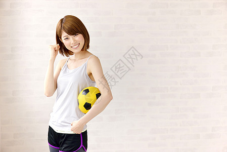 年轻女性手拿足球加油形象图片