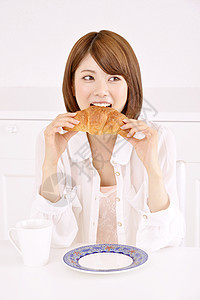 拿着面包在吃的女性图片