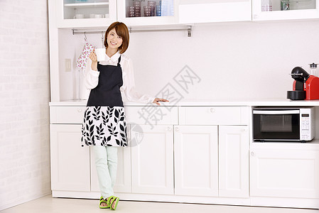 站在厨房间的年轻女性图片