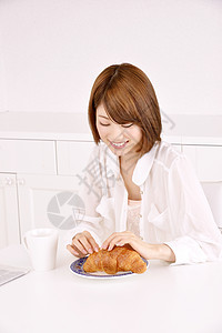 年轻女性吃早餐面包图片