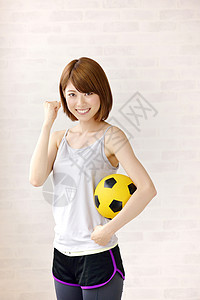抱着足球的运动少女图片