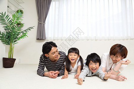 家庭四口在客厅地上玩耍休息图片