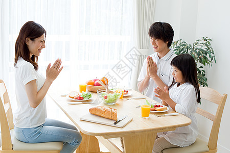 一家人在餐桌上吃饭的俯视图照片  |长凳上三口之家一起吃饭的背影