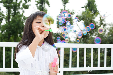 户外吹泡泡的小女孩图片