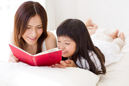 母亲陪着小女孩看书图片