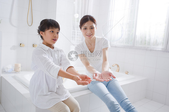 父母和孩子在浴缸里玩肥皂泡图片