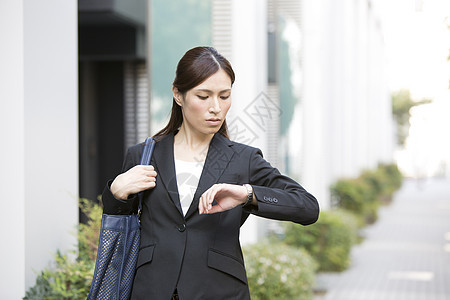 户外看手表的商务女性图片