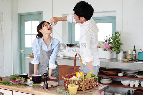 厨房里给妻子喂食物的丈夫图片