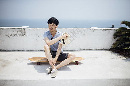 夏日海边滑板上的男青年图片