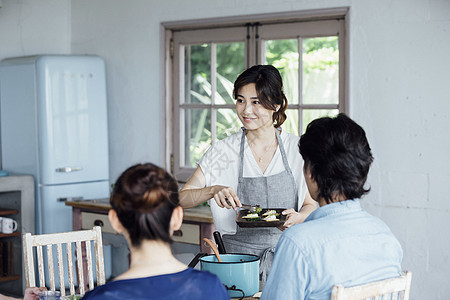 家庭聚会上给朋友准备食物的妇女图片