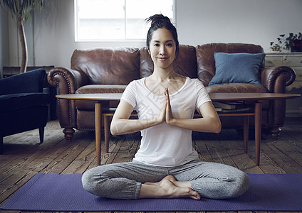 在瑜伽垫上锻炼的女性图片