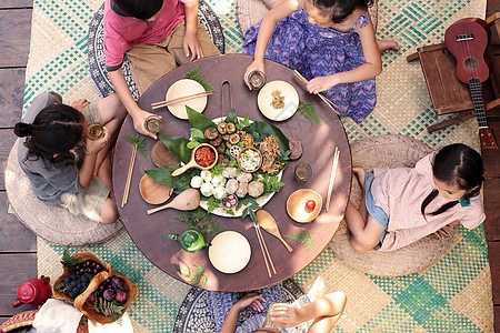 围绕野餐桌吃饭的一家人图片