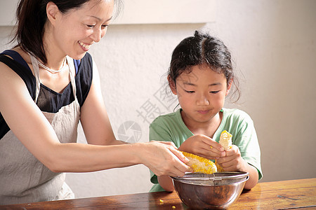 孩子和家长一起剥玉米背景图片