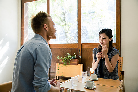 木纹餐桌咖啡店约会的异国情侣背景