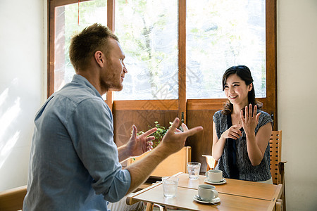 在咖啡店聊天约会的异国情侣图片