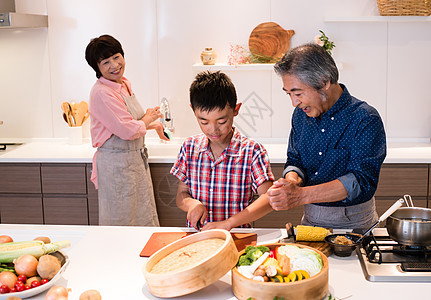 和孩子一起烹饪食材的祖父母图片