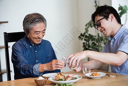 父子餐桌吃饭倒酒图片