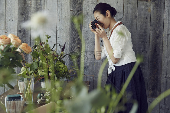 成熟知性女人给花束拍照图片