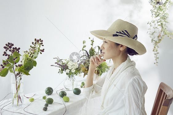 花瓶前戴草帽的妇女图片