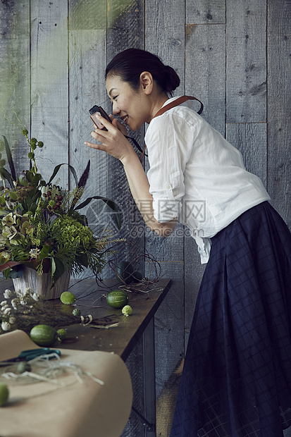 成熟知性女人给花束拍照图片