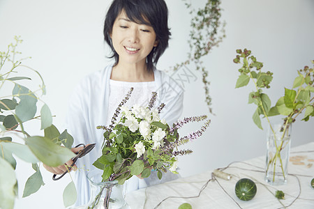 修剪鲜花布置花艺的妇女图片