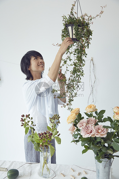 修剪鲜花布置花艺的妇女图片