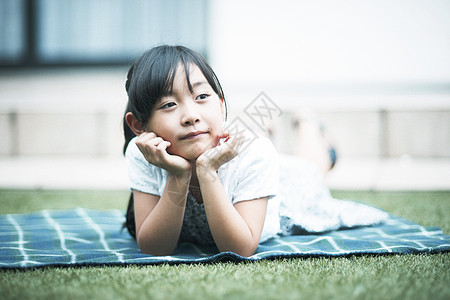 户外趴在草坪上的小女孩图片