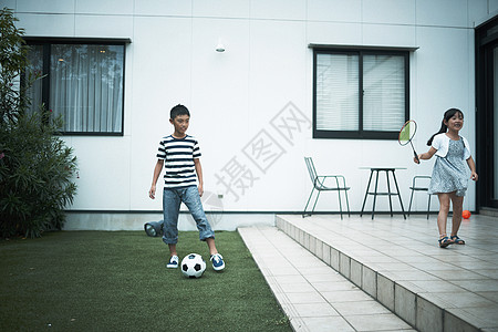 小朋友在花园里踢球打羽毛球图片