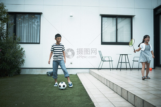 小朋友在花园里踢球打羽毛球图片