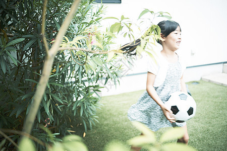 花园里拿着足球的小女孩图片