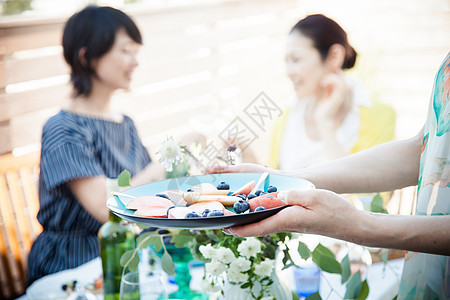 花园聚会上手拿餐盘的妇女图片